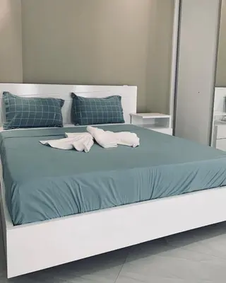 a white bed with blue sheets and towels on it at NOBRE LUZ T2 Boa Vista in Sal Rei