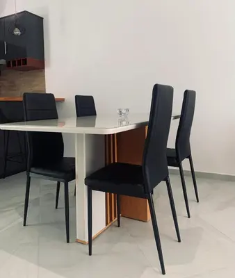 a table with four black chairs around it at NOBRE LUZ T2 Boa Vista in Sal Rei