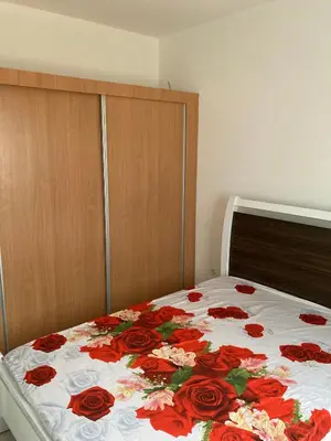 a bed with a floral comforter on top of it at Prédio IFH Maio in Vila do Maio
