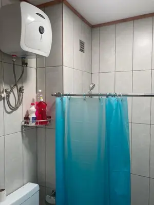 a shower with a blue shower curtain in a bathroom at Prédio IFH Maio in Vila do Maio