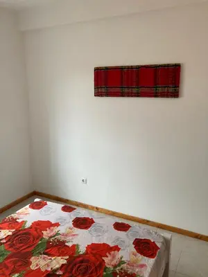 a bedroom with a bed with red roses on it at Prédio IFH Maio in Vila do Maio
