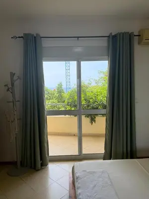 a bedroom with a window with a view of a balcony at Mira Mar Condominium, Palmarejo Baixo in Praia