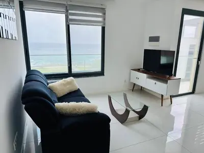 a living room with a blue chair and a television at Sweet Apartment Palmarejo - Marina Residence in Praia