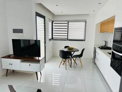 a kitchen with a television and a table and chairs at Sweet Apartment Palmarejo - Marina Residence in Praia