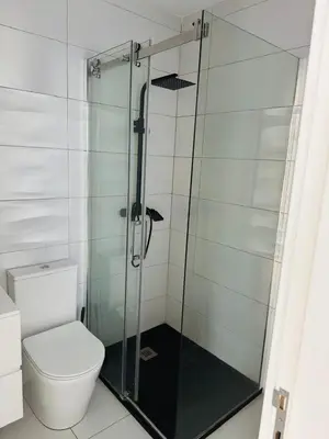 a glass shower in a bathroom with a toilet at Sweet Apartment Palmarejo - Marina Residence in Praia