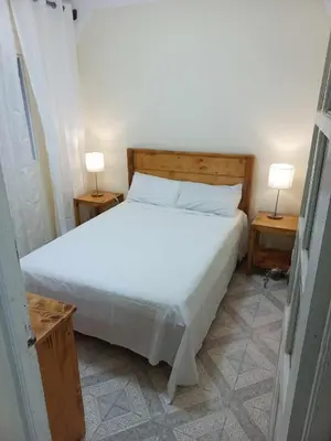 a bedroom with a white bed and two night stands at Casatata in São Filipe