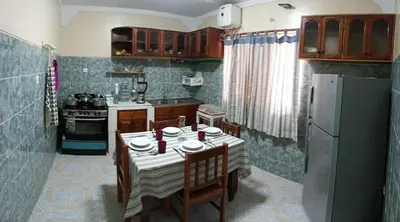 a kitchen with a table with chairs and a refrigerator at Casatata in São Filipe