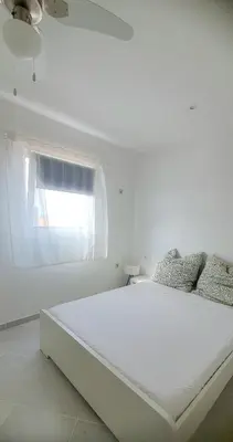 a white bedroom with a large bed with a window at Residência Alto Saco, Ocean-view double room in Tarrafal