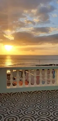 a view of the ocean at sunset from a balcony at Residência Alto Saco, Ocean-view double room in Tarrafal