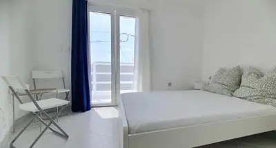 a white bedroom with a bed and a window at Residência Alto Saco, Ocean-view double room in Tarrafal