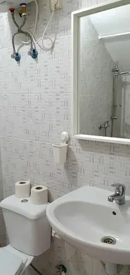 a bathroom with a sink and a toilet and a mirror at Studio Alto Saco in Tarrafal