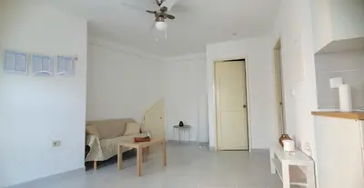 a white living room with a couch and a table at Studio Alto Saco in Tarrafal