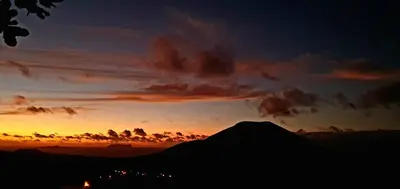 a sunset with a silhouette of a mountain at Studio Alto Saco in Tarrafal