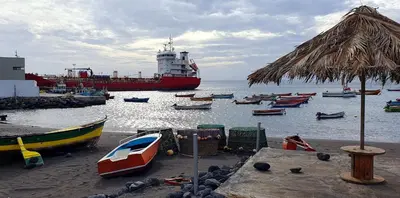 a large boat in the water with many boats at Residência Alto Saco, Double room with private bathroom in Tarrafal