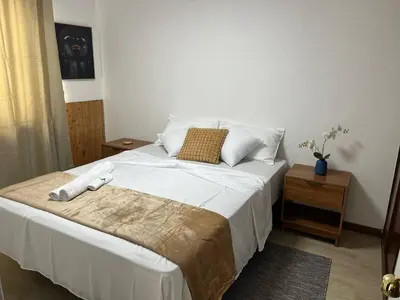 a bedroom with a large bed with white sheets and pillows at Plateau- Sea View Apartment in Praia