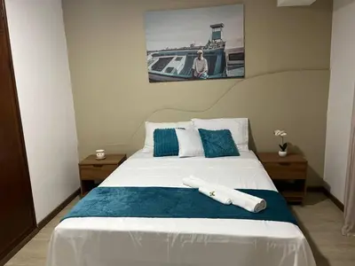 a bedroom with a bed with blue and white pillows at Plateau- Sea View Apartment in Praia