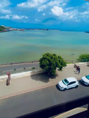 two cars parked on a street next to a beach at Plateau- Sea View Apartment in Praia