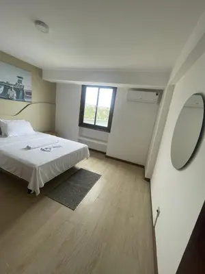 a bedroom with a white bed and a window at Plateau- Sea View Apartment in Praia