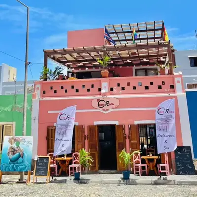 a pink building with chairs and tables in front of it at Crown Paradise Beach Lagoon Studio in Sal Rei