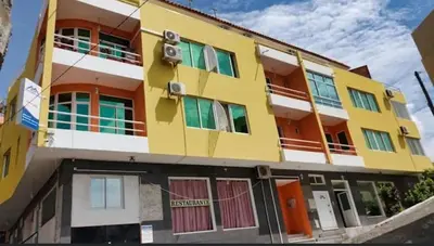 a yellow building with colorful doors and windows at Chã de Areia Lounge Vista Mar - Apartamento T2 in Praia