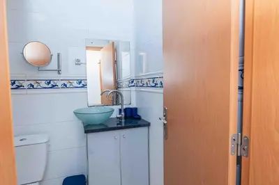 a small bathroom with a sink and a toilet at Chã de Areia Lounge Vista Mar - Apartamento T2 in Praia