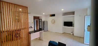 a living room with a refrigerator and a tv at Refugio Cesaria in Tarrafal
