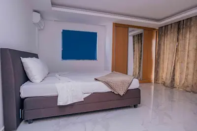 a small bed in a room with a blue board at Otro Residence in Praia