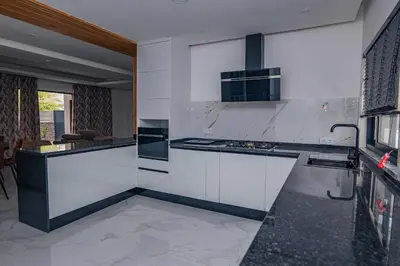 a kitchen with white cabinets and a stove top oven at Otro Residence in Praia
