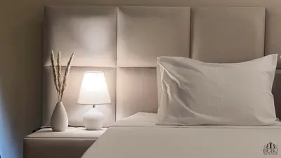 a white bed with a white pillow and a lamp at Serenity in Praia