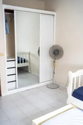 a bedroom with a mirror and a fan at T2 com escritório - Férias Teletrabalho in Praia