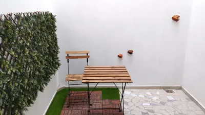 a wooden bench sitting next to a white wall at Sal Casa VILLAGE in Santa Maria