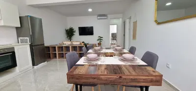 a kitchen and dining room with a wooden table and chairs at Sal Casa VILLAGE in Santa Maria
