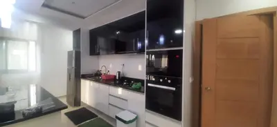 a kitchen with white cabinets and black appliances at Lucy aparte in Praia