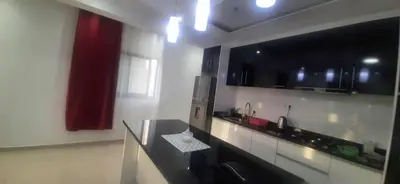 a kitchen with black and white counters and a red curtain at Lucy aparte in Praia