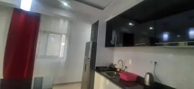 a kitchen with black and red cabinets and a sink at Lucy aparte in Praia
