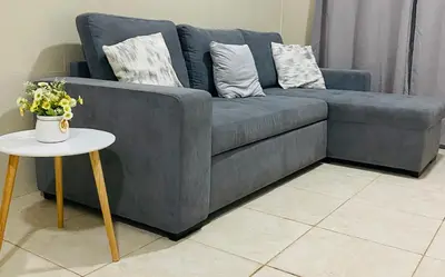 a blue couch sitting in a living room with a table at Large 1 bedroom Apt with sofa bed in Santa Maria