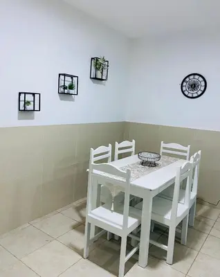 a white table with white chairs and a clock on the wall at Large 1 bedroom Apt with sofa bed in Santa Maria
