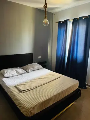 a bed in a bedroom with blue curtains and a lamp at Santa Maria Central Stay in Santa Maria