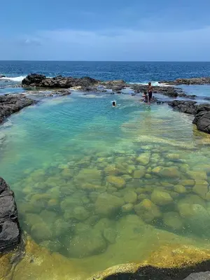 people swimming in a pool of water on the beach at Santa Maria Central Stay in Santa Maria