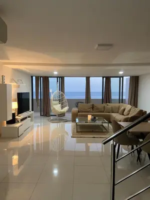 a large living room with a couch and a television at Nice Duplex in Praia