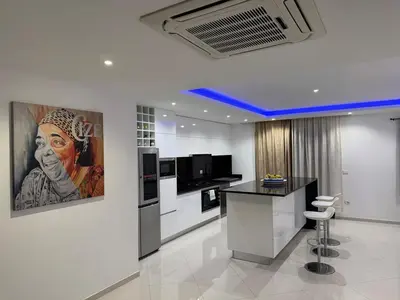 a kitchen with a painting of a woman on the wall at Penthouse Ocean View in Mindelo