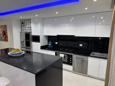 a kitchen with white cabinets and a bowl of fruit on a counter at Penthouse Ocean View in Mindelo
