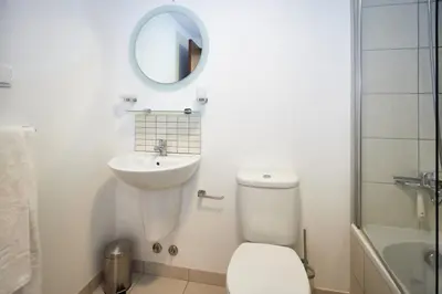 a bathroom with a toilet and a sink and a mirror at Lux 1BR S Maria 90 Day Stay in Santa Maria