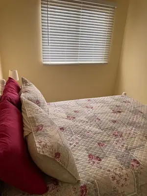 a bed with two pillows on it with a window at Affordable Beach Town Apartment in Santa Maria
