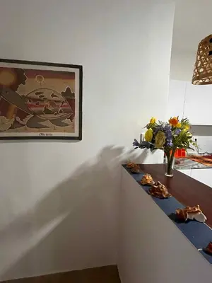 a table with a vase of flowers and a painting at Casa Minuxa in Santa Maria