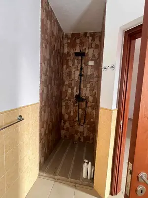 a shower in a room with a stone wall at Casa Minuxa in Santa Maria
