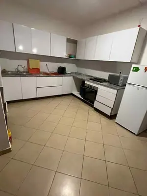 a kitchen with white cabinets and a white refrigerator at Casa Minuxa in Santa Maria