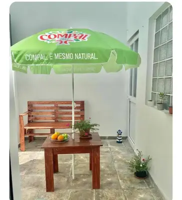 a table with a green umbrella on a patio at Tarrafal snuggle in Tarrafal