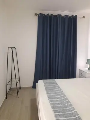 a bedroom with a bed and a blue curtain at Tarrafal snuggle in Tarrafal