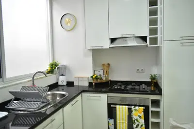 a kitchen with white cabinets and a stove top oven at Casa Berta - Downtown Apartment in Praia
